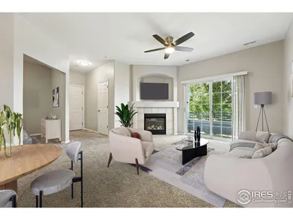 a living room with furniture a fireplace and a large window