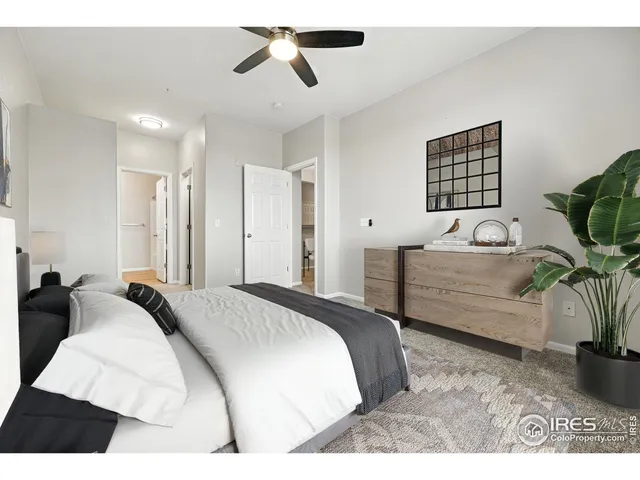 a bedroom with a bed a couch and potted plant