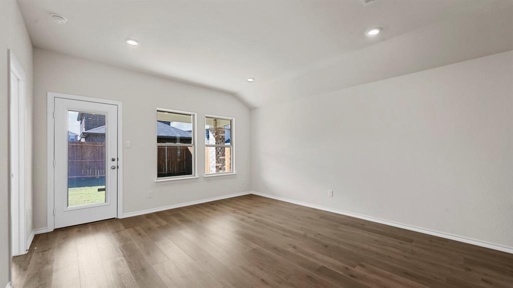 1663 Blaire Drive Tyler, TX 75704 - Photo 9 of 26 Spacious room featuring wood-finish flooring, a vaulted ceiling, recessed lighting, and multiple windows