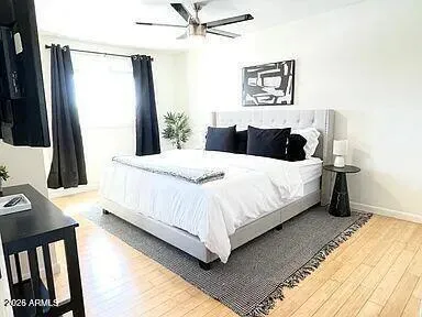 a bedroom with a bed and a flat tv screen on dresser
