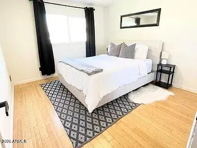 a bedroom with a bed and wooden floor