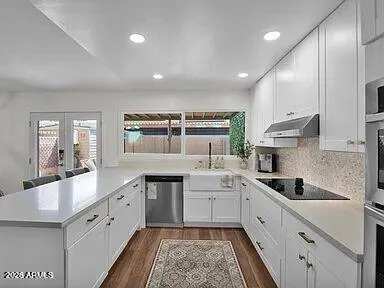 a large white kitchen with a sink stove and cabinets