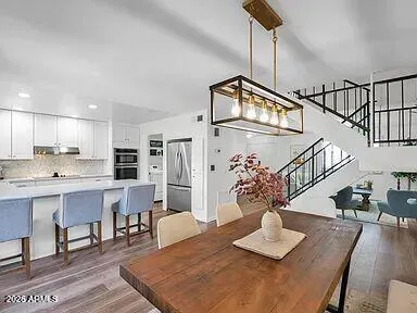 a view of a dining room with furniture a chandelier and wooden floor