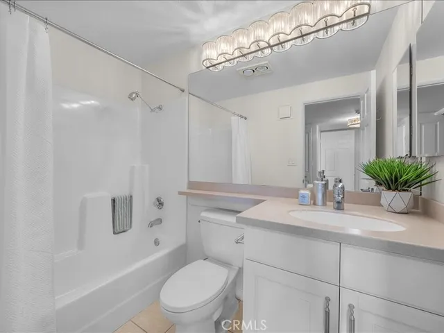 a bathroom with a granite countertop sink a toilet and shower