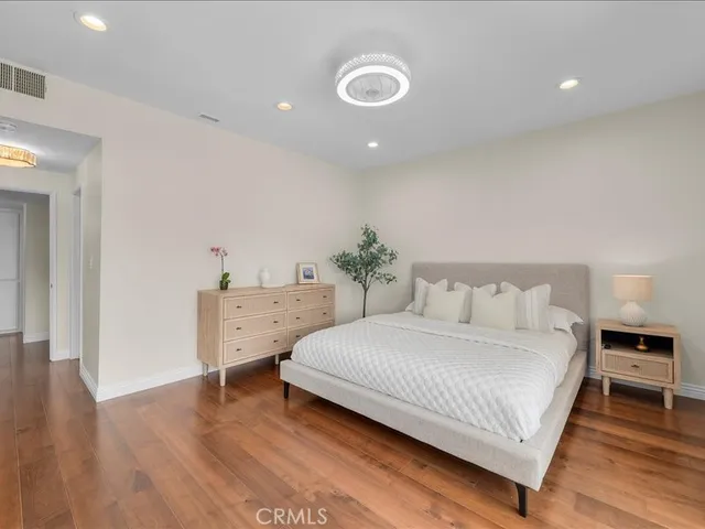 a bedroom with a bed and wooden floor