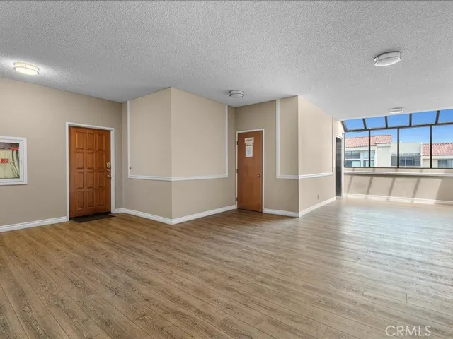 an empty room with wooden floor and mirror