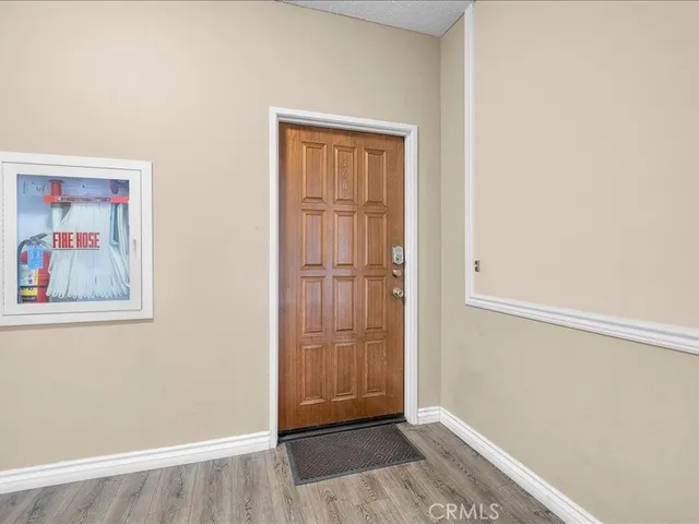 a view of a dining room and livingroom with furniture wooden floor a chandelier