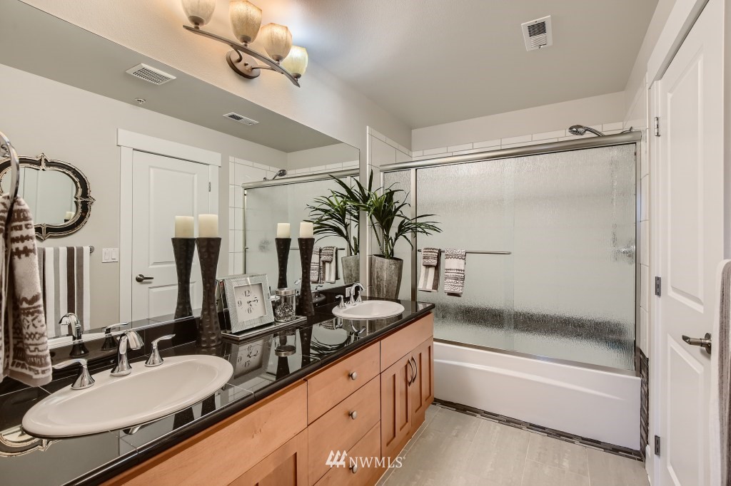 2115 201st Place Southeast, Unit B5 Bothell, WA 98012 - Photo 20 of 28 a bathroom with a granite countertop sink a mirror a vanity and a bathtub