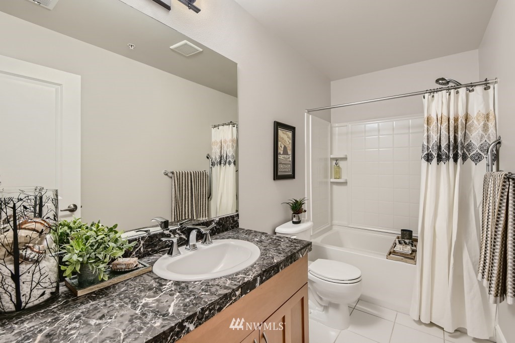 2115 201st Place Southeast, Unit B5 Bothell, WA 98012 - Photo 25 of 28 a bathroom with a granite countertop sink mirror vanity and toilet