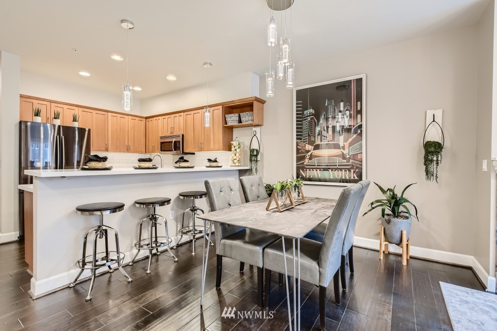 2115 201st Place Southeast, Unit B5 Bothell, WA 98012 - Photo 7 of 28 a kitchen with stainless steel appliances kitchen island granite countertop a dining table chairs and granite counter tops