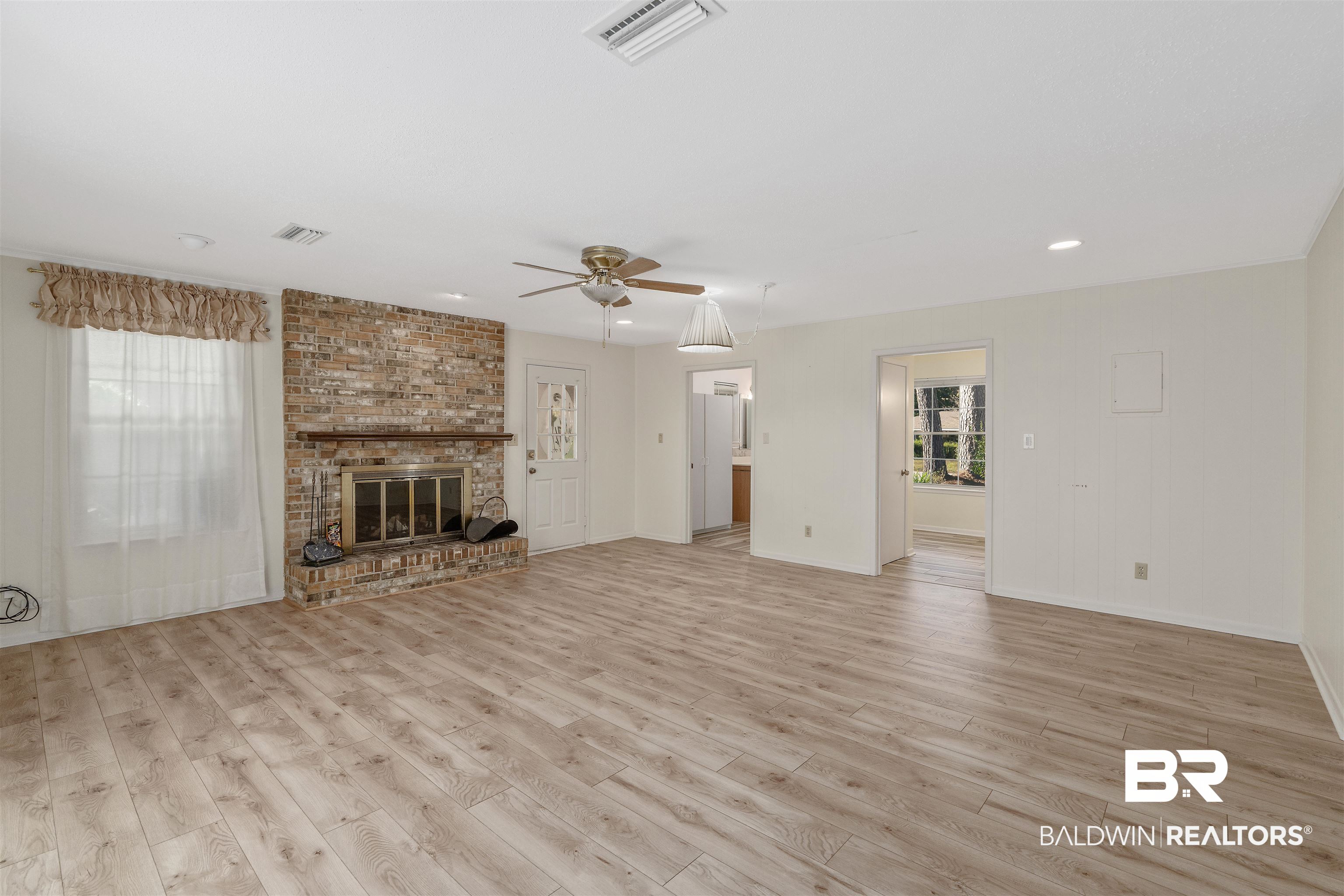 621 Spanish Main Spanish Fort, AL 36527 - Photo 14 of 29 Unfurnished living room featuring ceiling fan, a fireplace, and light hardwood / wood-style flooring
