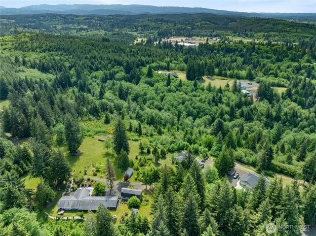 an aerial view of a houses with a yard and lake view