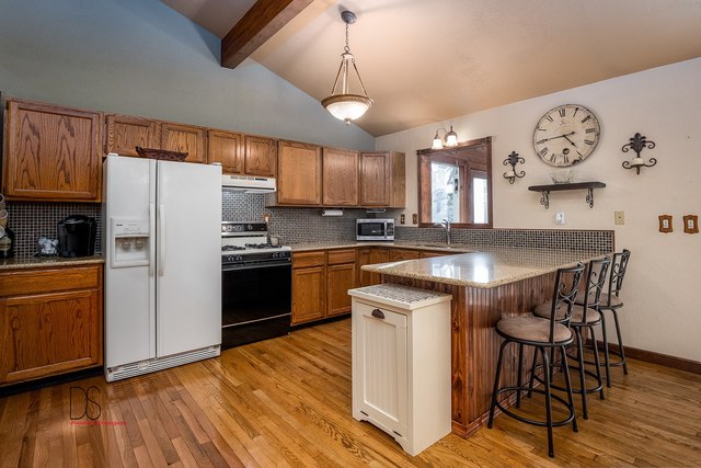 2983 East 1520th Road Ottawa, IL 61350 - Photo 8 of 21 a kitchen with granite countertop a refrigerator a stove a sink and white cabinets with wooden floor