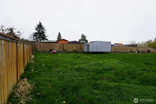 a view of yard with trees in the background