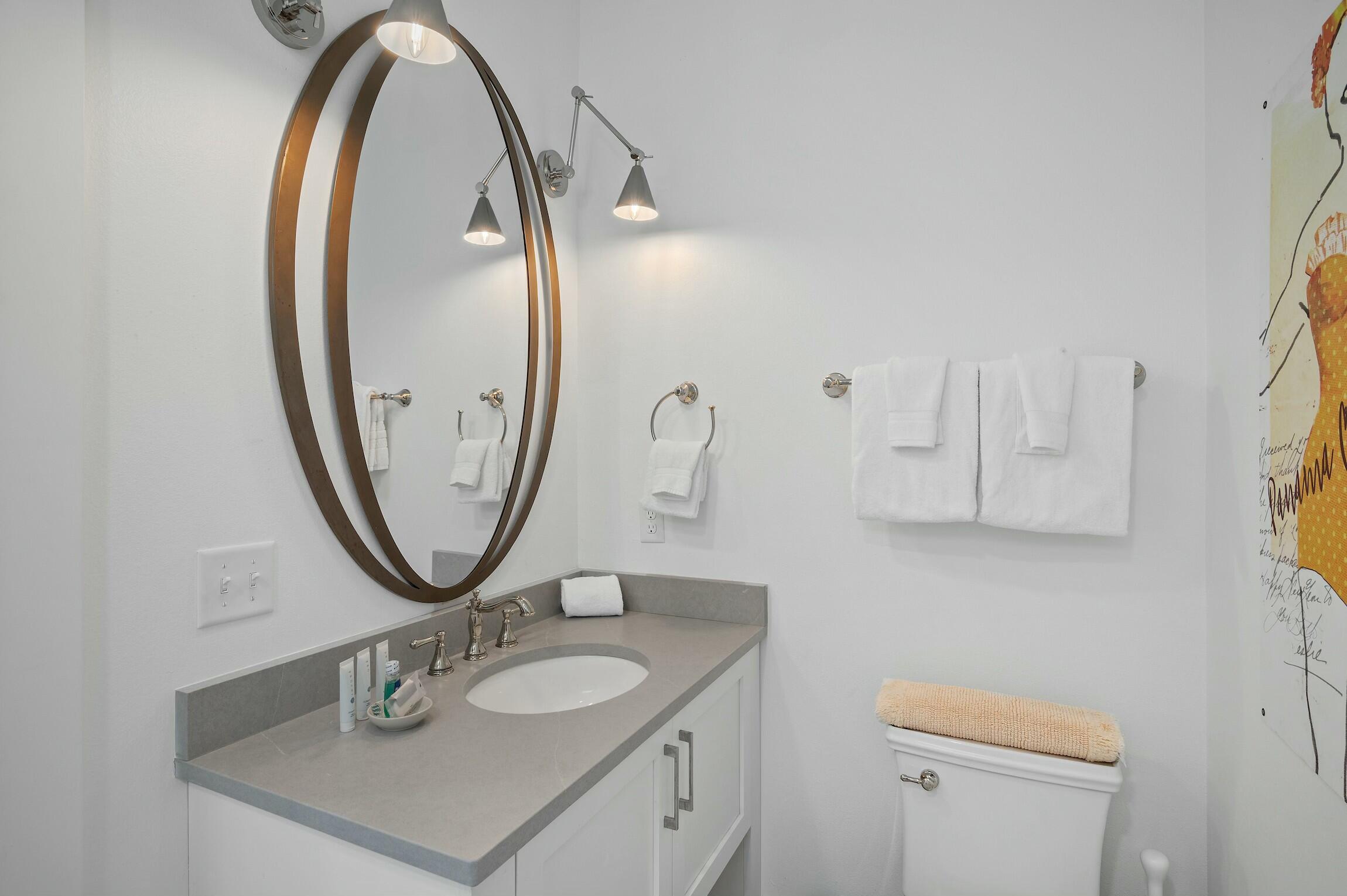 16515 Front Beach Road Panama City Beach, FL 32413 - Photo 11 of 46 a bathroom with a sink a mirror and a toilet