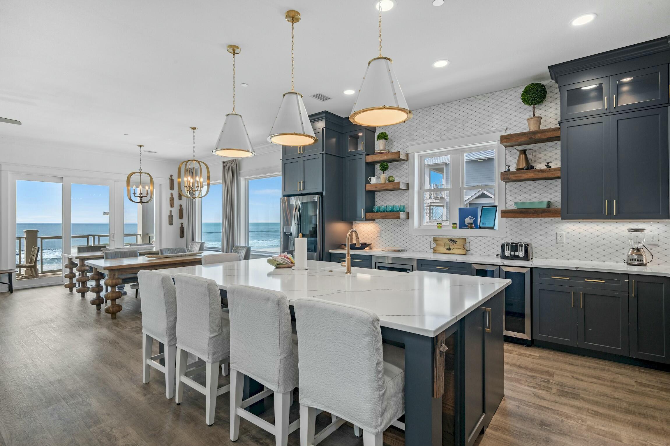 16515 Front Beach Road Panama City Beach, FL 32413 - Photo 21 of 46 a kitchen with stainless steel appliances granite countertop a stove a sink a oven a dining table and chairs