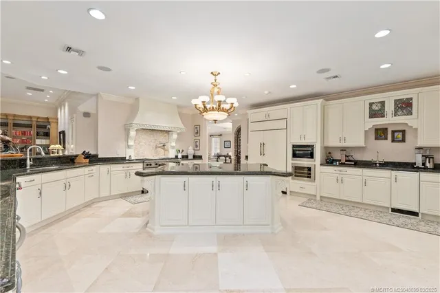 a living room with furniture chandelier and a large window