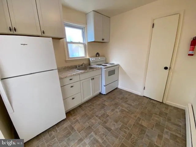 a kitchen with white cabinets and white appliances