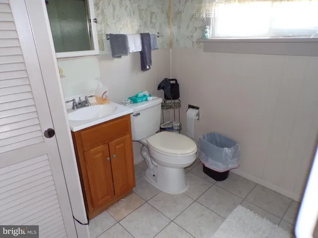 a white toilet sitting next to a bathroom sink and a window
