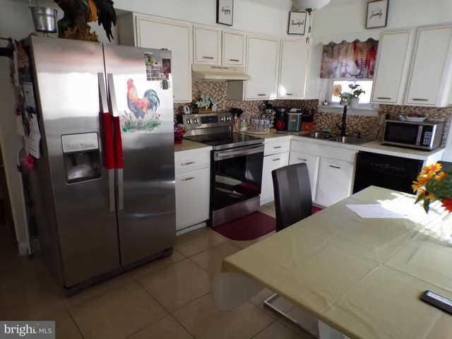 a kitchen with refrigerator and cabinets