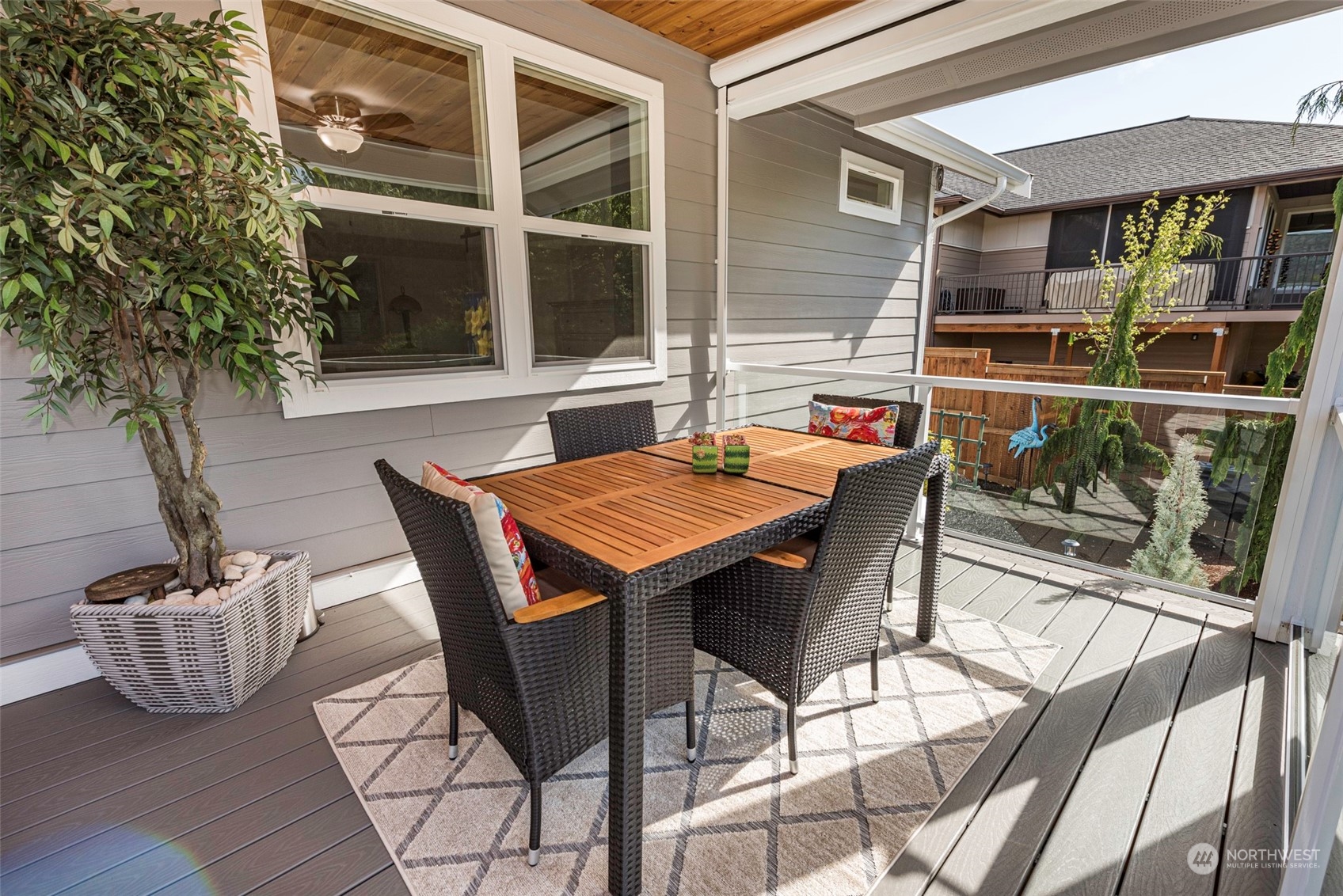 331 Morgison Loop Sequim, WA 98382 - Photo 36 of 39 a view of a patio with table and chairs potted plants with wooden floor and fence