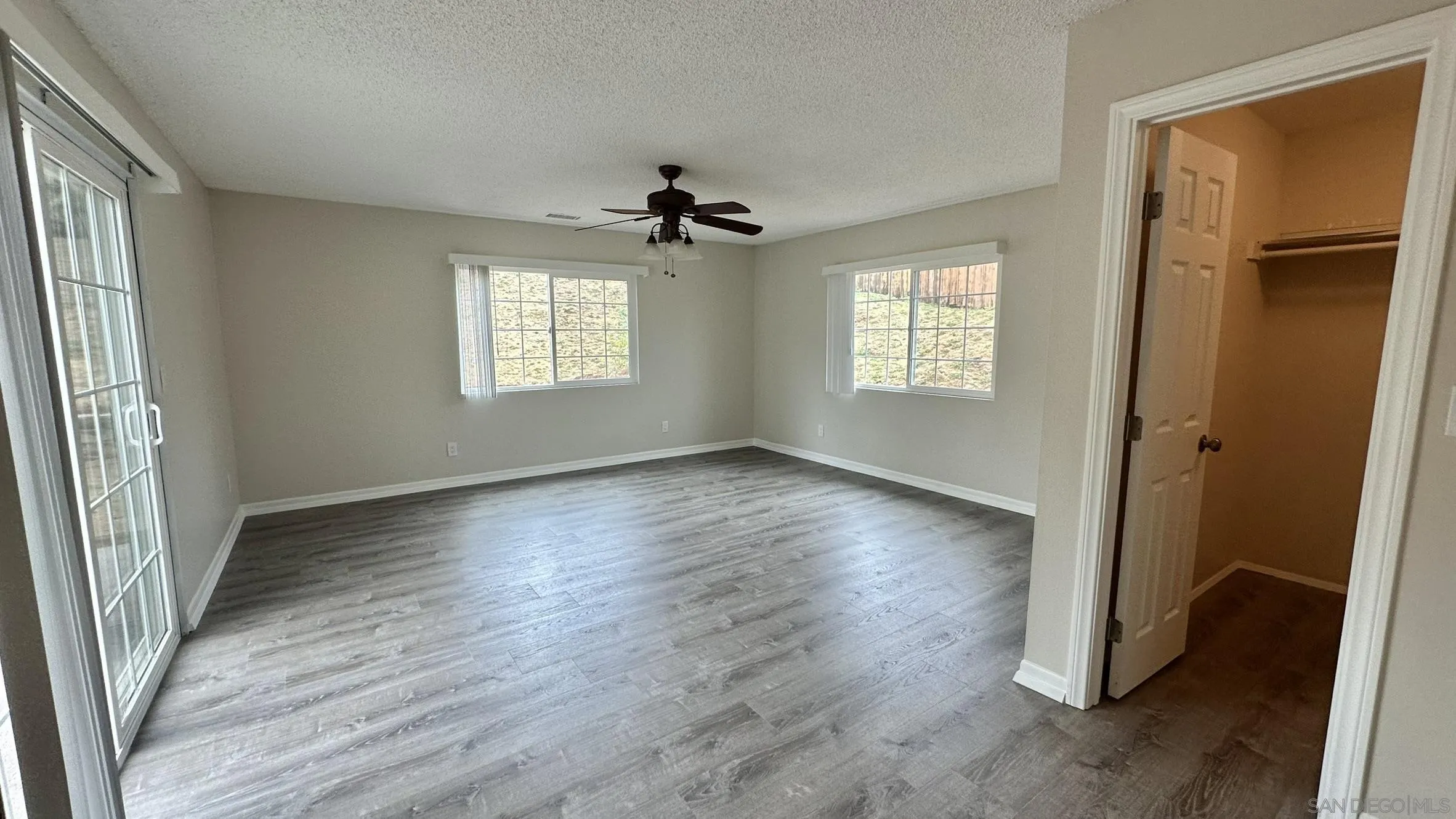 16142 Dartolo Road Ramona, CA 92065 - Photo 21 of 31 an empty room with wooden floor and windows