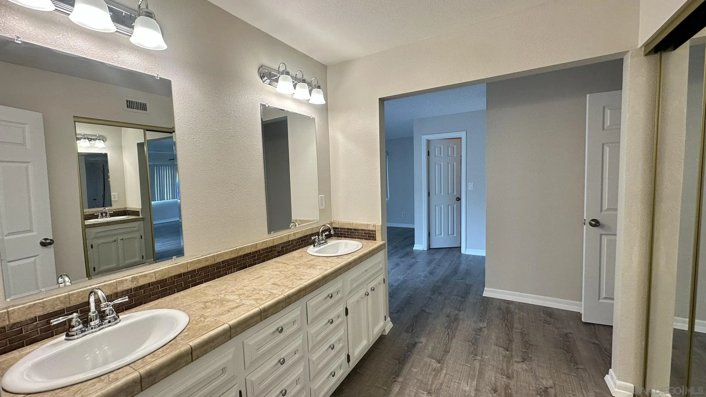 16142 Dartolo Road Ramona, CA 92065 - Photo 24 of 31 a bathroom with double vanity sinks and a mirror