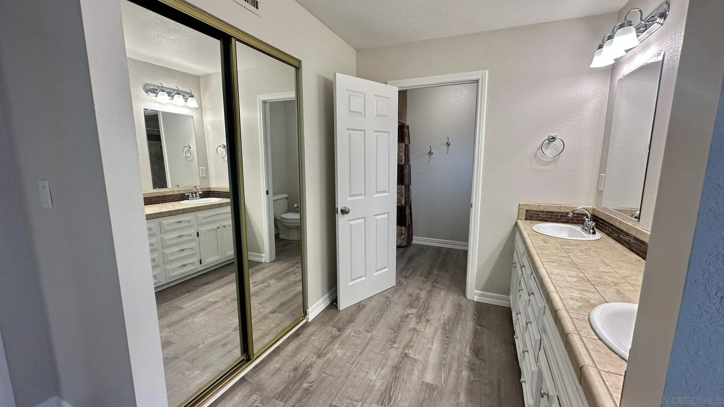 16142 Dartolo Road Ramona, CA 92065 - Photo 27 of 31 a bathroom with a granite countertop sink a vanity and a mirror