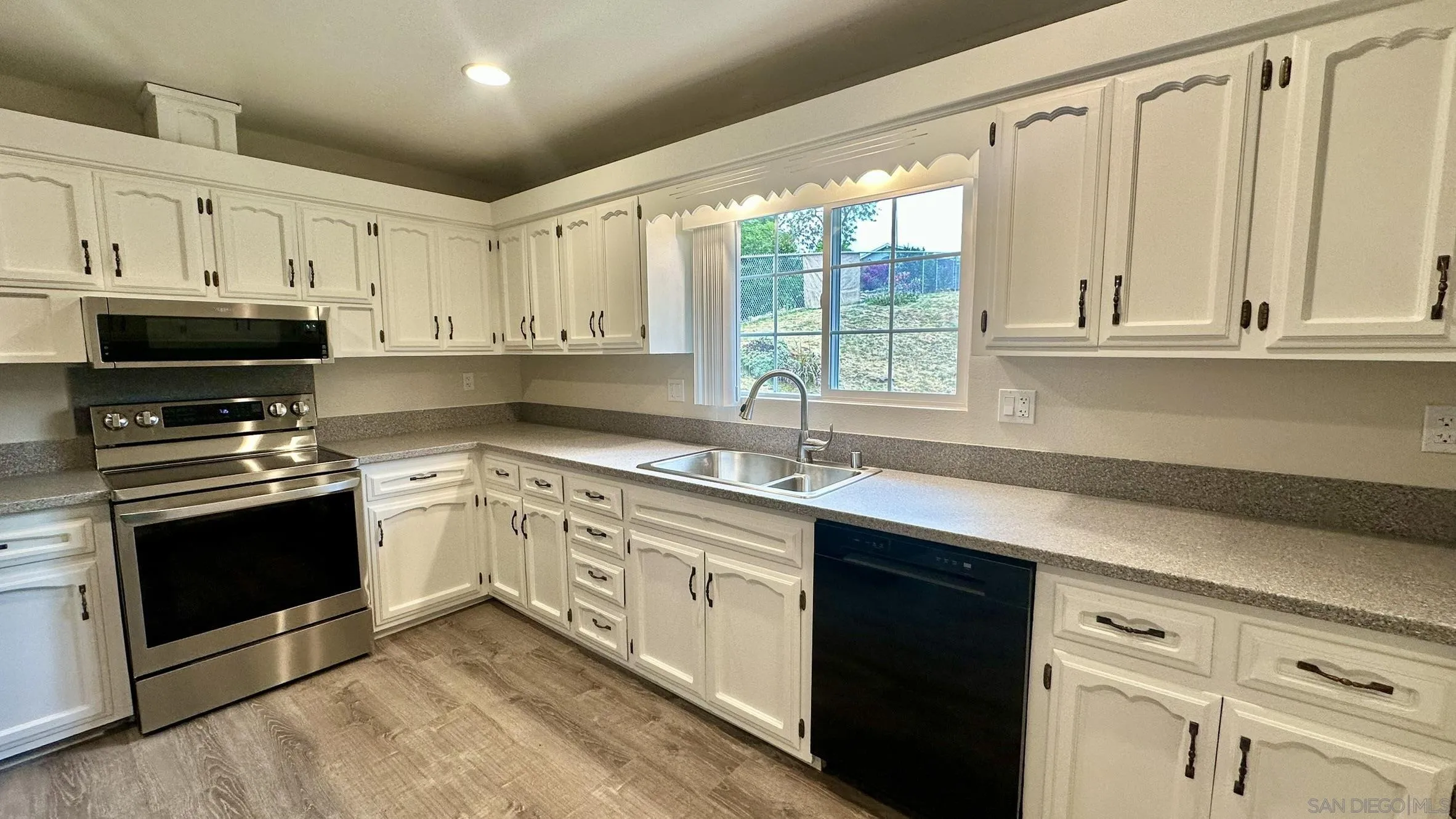 16142 Dartolo Road Ramona, CA 92065 - Photo 7 of 31 a kitchen with stainless steel appliances granite countertop white cabinets a sink and a stove
