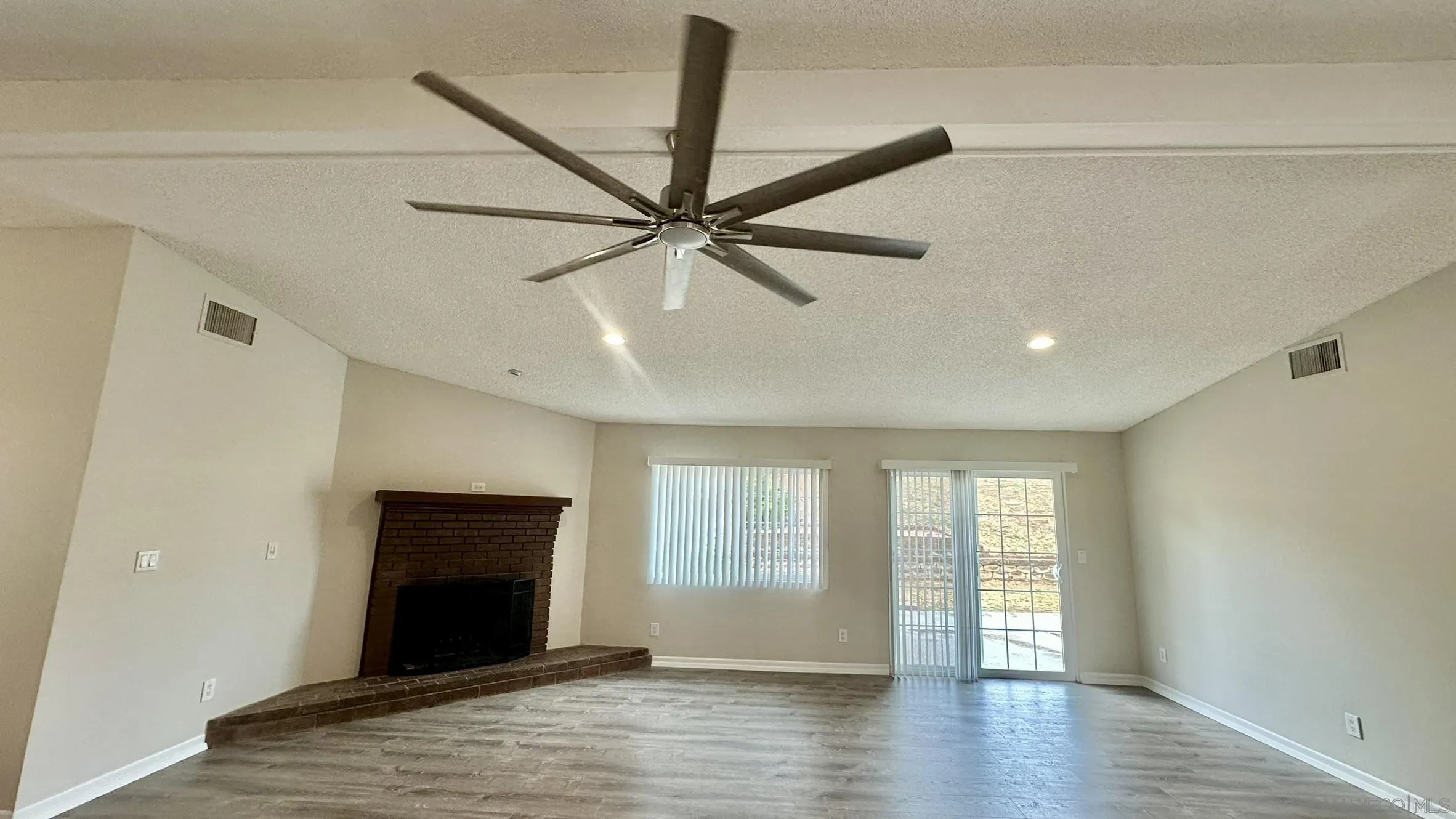 16142 Dartolo Road Ramona, CA 92065 - Photo 10 of 31 a view of an empty room with window and wooden floor