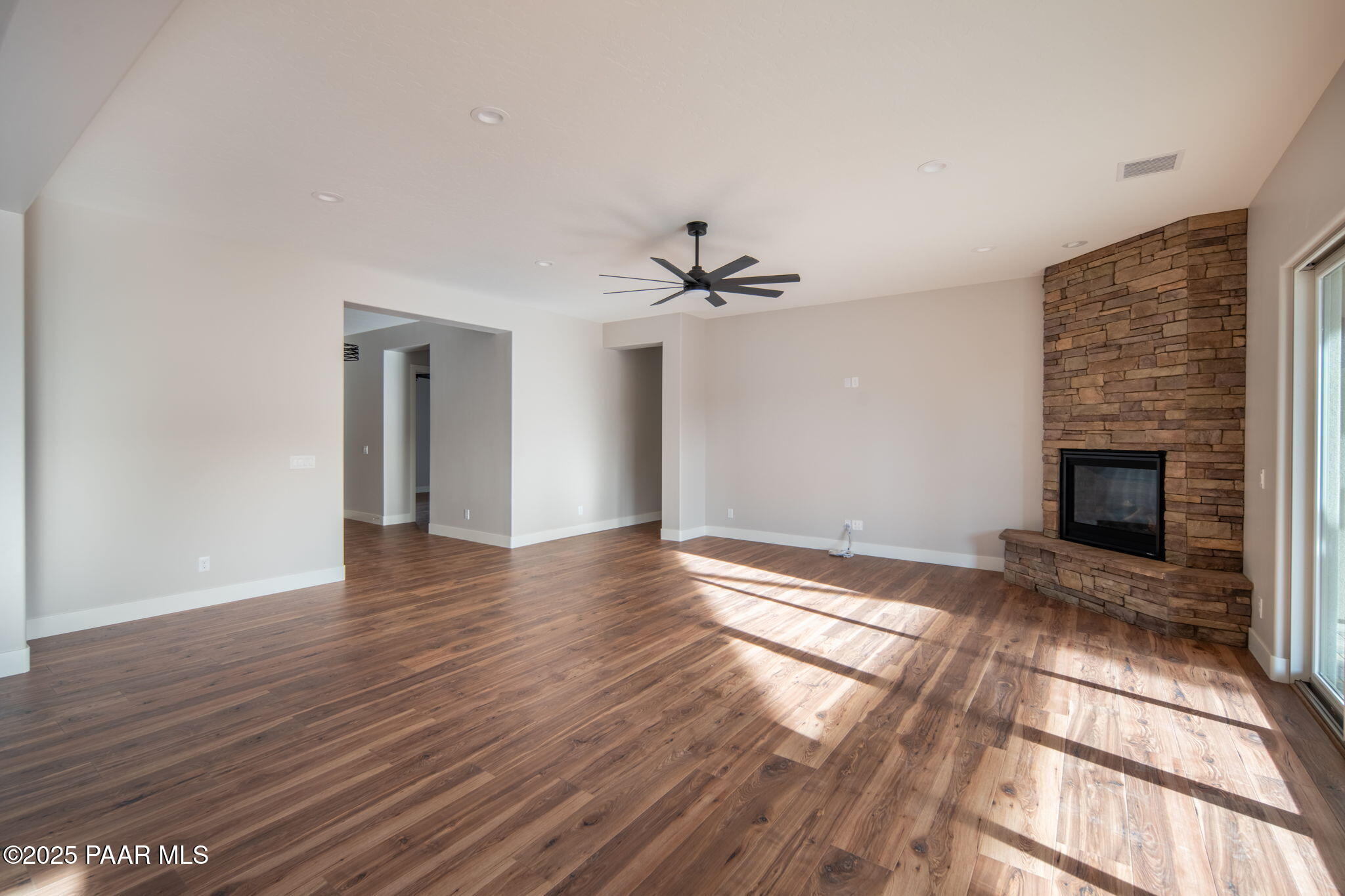 9596 North Bridle Ridge Road Prescott, AZ 86305 - Photo 14 of 58 a view of an empty room with wooden floor fireplace and a window