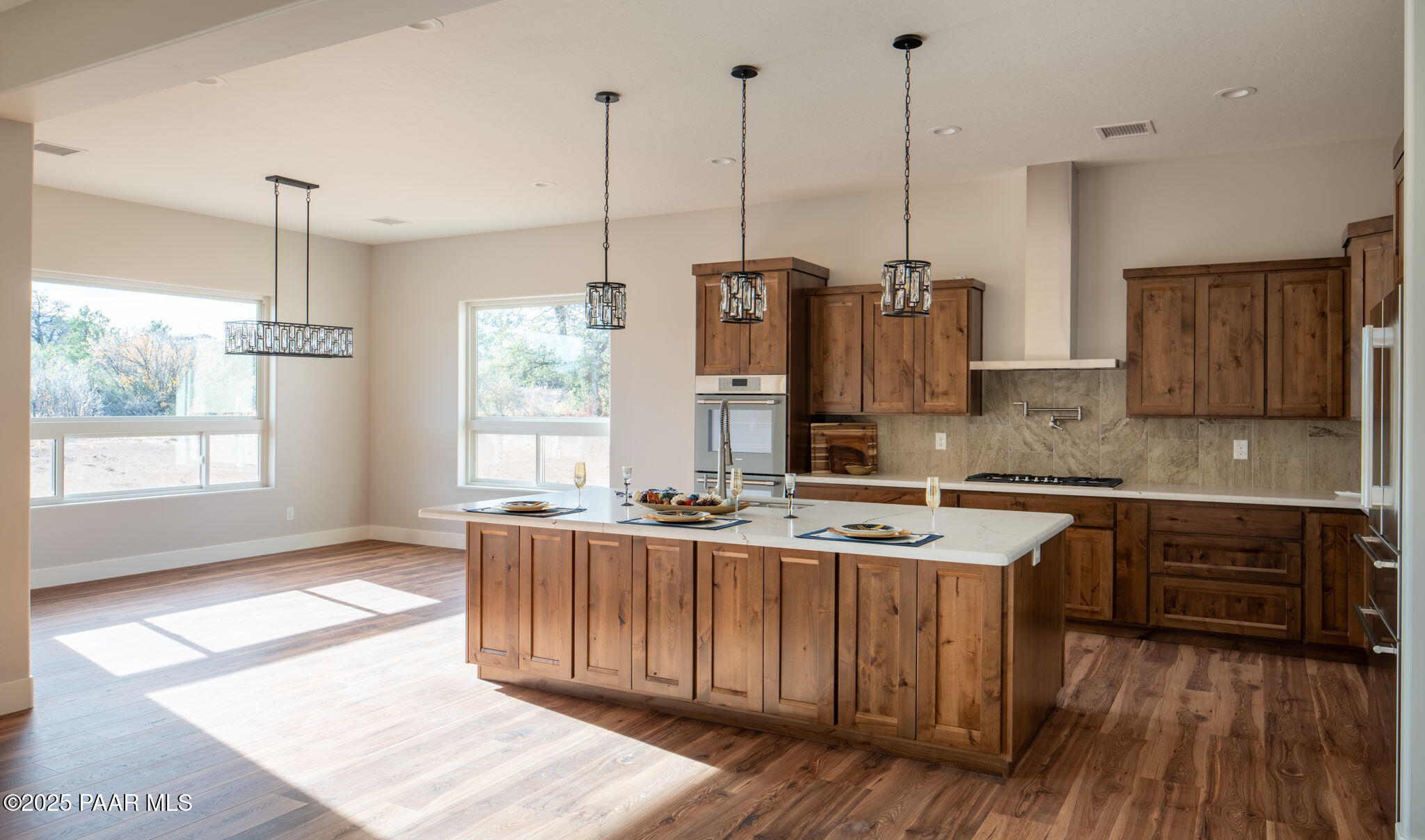 9596 North Bridle Ridge Road Prescott, AZ 86305 - Photo 17 of 58 a kitchen with stainless steel appliances granite countertop cabinets a sink a stove a kitchen island and a wooden floors