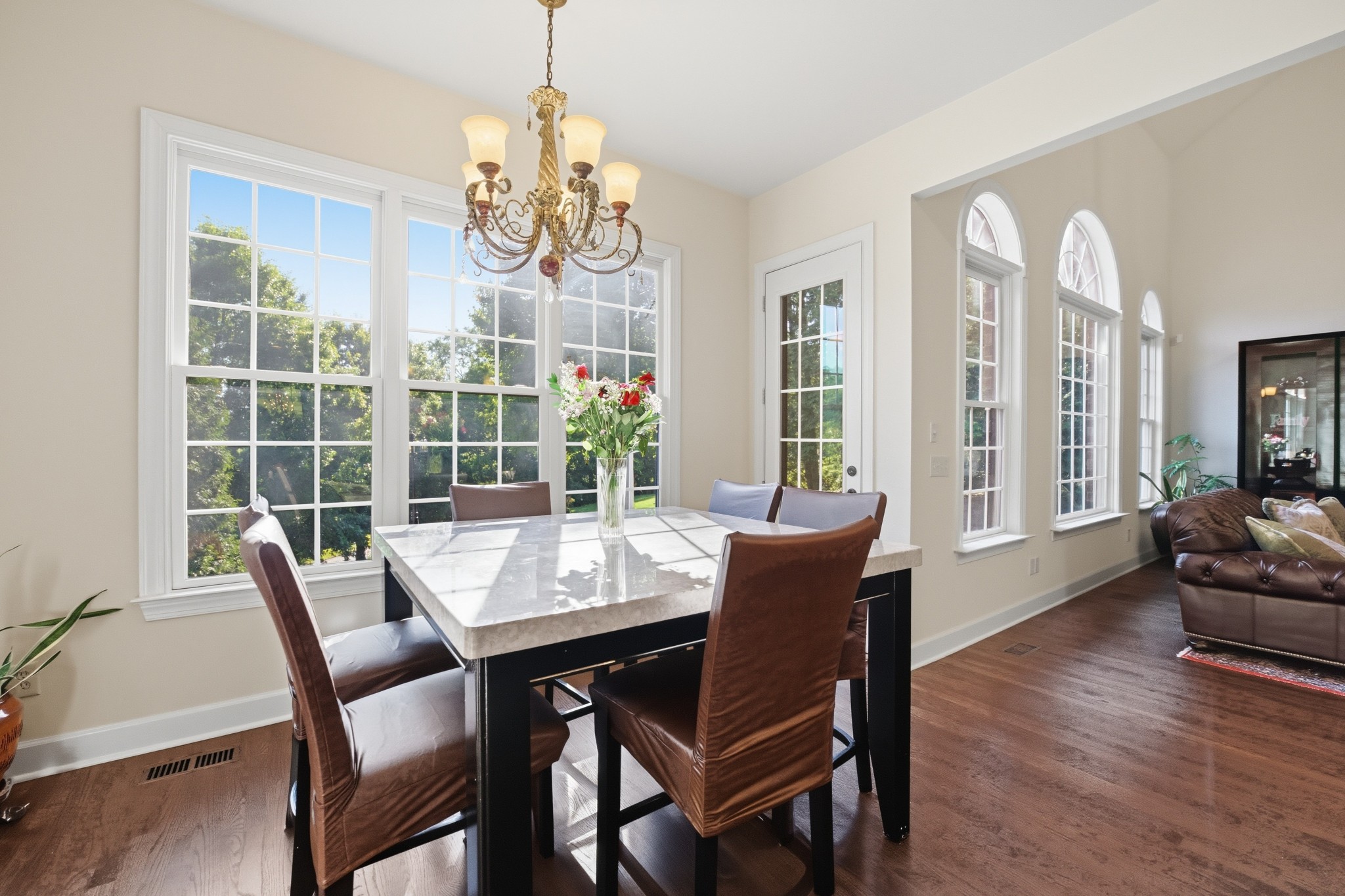 319 Hamlets End Way Franklin, TN 37067 - Photo 21 of 54 a dining room with wooden floor a chandelier a wooden table and chairs
