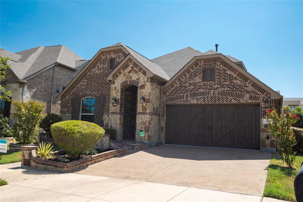 a front view of a house with a garden and garage