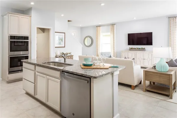 a kitchen with granite countertop a sink and a stove top oven