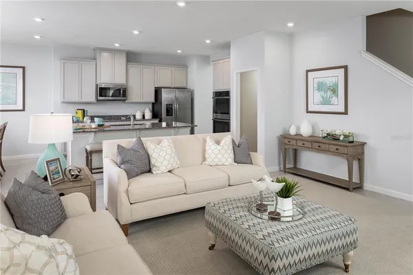 a living room with furniture kitchen view and a potted plant