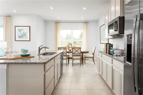 a kitchen with stainless steel appliances granite countertop a sink and a refrigerator
