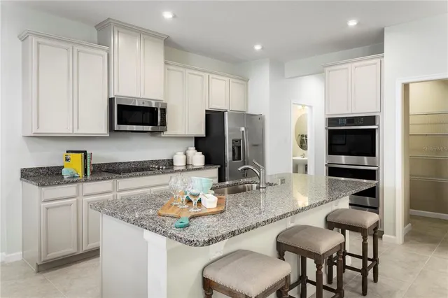 a kitchen with granite countertop kitchen island cabinets and stainless steel appliances