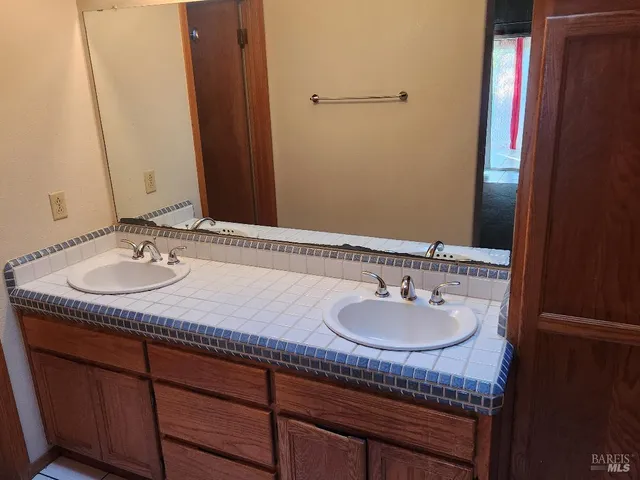 a bathroom with a granite countertop sink and a mirror