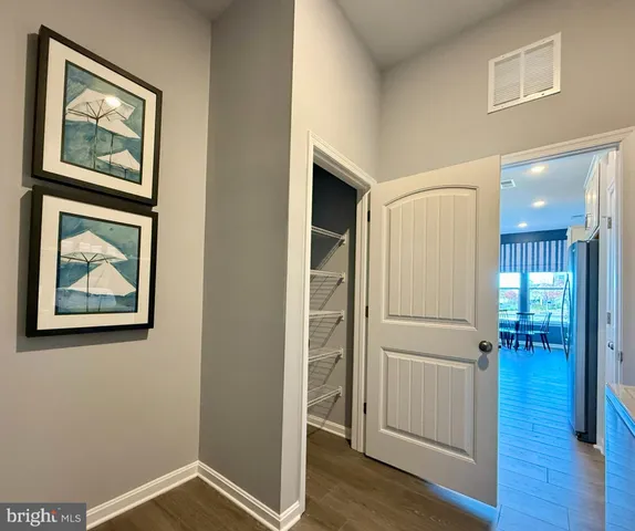 a view of a hallway with wooden floor and closet