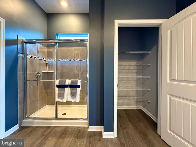 a room with wooden floor and a glass door shower