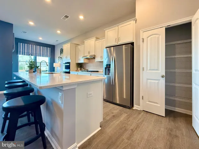 a kitchen with kitchen island a refrigerator stove and microwave