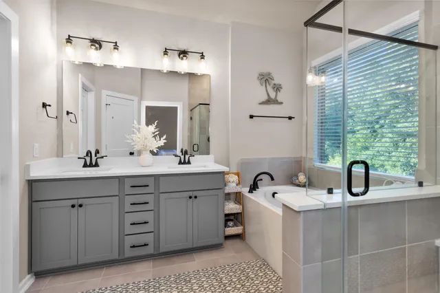 a bedroom with a bed and a flat tv screen on dresser