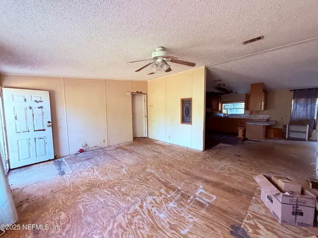 a view of a livingroom with furniture and a ceiling fan