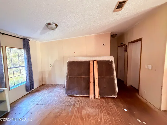 a kitchen with stainless steel appliances wooden floors stove top oven and cabinets