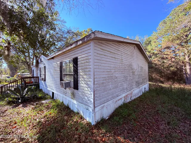a view of backyard with wooden fence and large trees