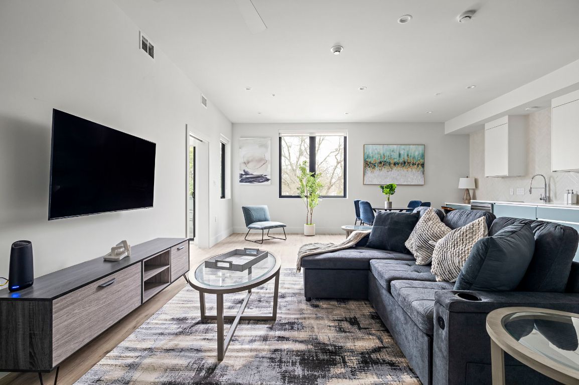 a living room with furniture a flat screen tv and a window