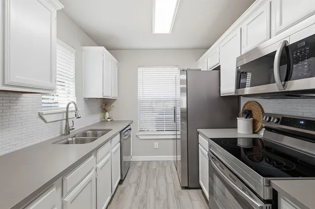 a kitchen with stainless steel appliances granite countertop a sink stove and cabinets