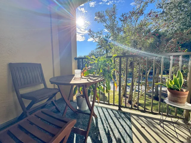 a front view of a house with a yard and palm trees