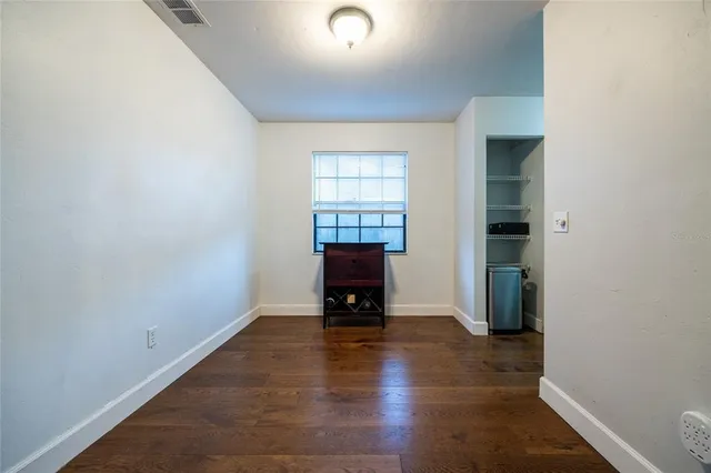 an empty room with a door and wooden floor